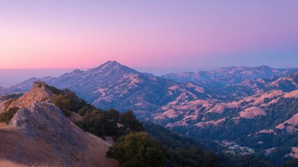 Obraz premium Majestic mountain range bathed in the soft hues of a serene sunset sky, a breathtaking natural vista.