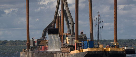 WORK AND TRANSPORT PONTOONS - The machines on deck platforms are working to deepening of a waterway in the lagoon  © Wojciech Wrzesień