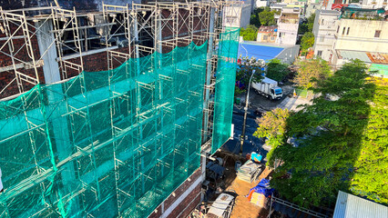 High-rise construction site with facade scaffolding and safety netting in Asia © Masha