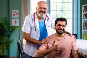 Experienced Indian physician and young patient smile confidently after positive medical checkup