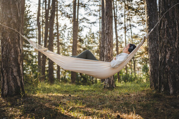 Fototapeta premium Young woman lying down on hammock and have guided meditation