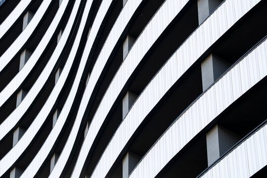 Abstract monochrome modern architecture facade with curves and lines showing contrast and shadows pattern background with graphic rhythm