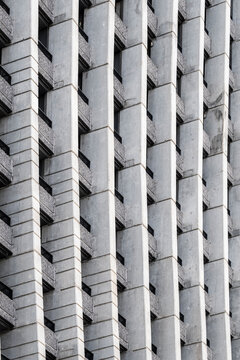 Abstract monochrome brutalist architecture facade in concrete with texture pattern grid and shadows creating stark modern background