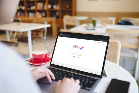 Bangkok, Thailand. January 16, 2026; A person using the Google search engine on a MacBook Pro laptop sitting at a terrazzo table in a bright cafe.