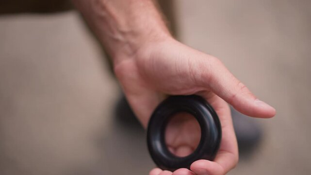 White Man Kneeling Squeezing Black Hand Ring With Force, Close Detail On Curled Fingers And Palm Pressure, Gritty Outdoor Surface, Concentrated Training For Grip And Forearm Power