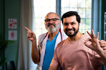 Experienced Indian physician and young patient smile confidently after positive medical checkup
