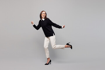 Full body young employee business woman corporate lawyer wear black sweater glasses shirt work in office run away hurry up look aside on area isolated on plain grey color background studio portrait.