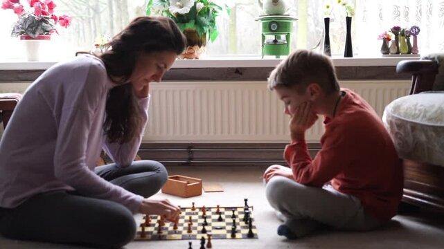 Mother and son playing chess at home