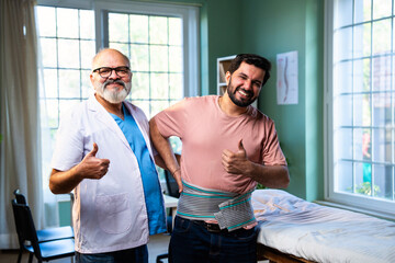Indian physiotherapist with happy patient showing thumbs up after back pain treatment