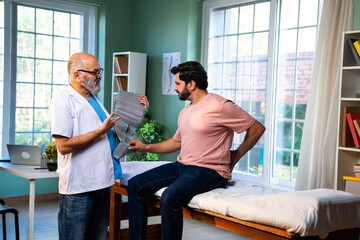 Indian physiotherapist with happy patient showing thumbs up after back pain treatment