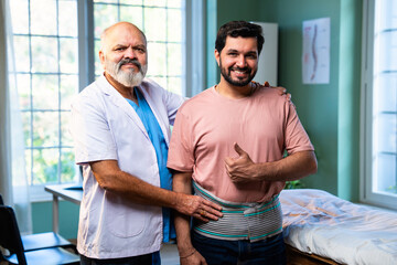 Indian physiotherapist with happy patient showing thumbs up after back pain treatment