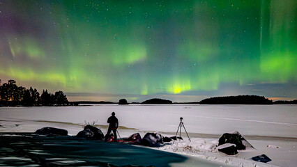 Northern lights dancing over frozen lake in north of Sweden.