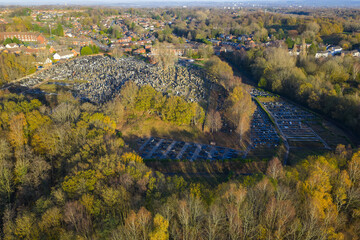 Aerial image of Rainsough Jewish Cemetery in Prestwich, showcasing the burial grounds bordered by dense autumn woodland and suburban housing.