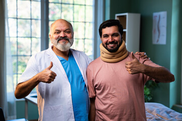Indian physiotherapist treating young patient with neck and shoulder pain in clinic