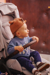 Little child enjoys a moment in a stroller