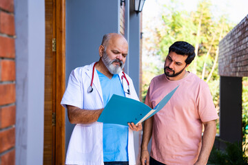 Indian doctor patient discuss case outdoors while reviewing medical details in nature