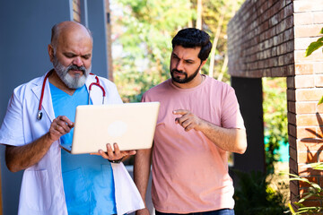 Indian doctor patient discuss case outdoors while reviewing medical details in nature