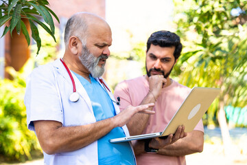 Indian doctor patient discuss case outdoors while reviewing medical details in nature