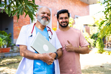 Indian doctor patient discuss case outdoors while reviewing medical details in nature