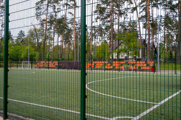 football field with white lines on the grass. With orange stands.
