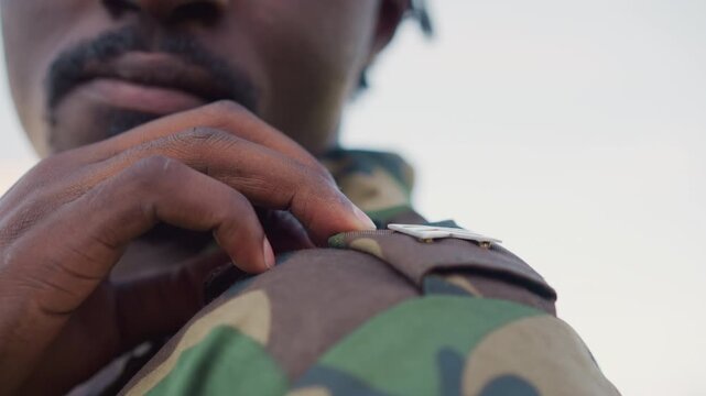 Detailed Closeup Of Officer Adjusting Shoulder Patch During Inspection, Focused Military Personnel Carefully Aligns Shoulder Rank Insignia On Camouflage Attire Before Official Ceremony