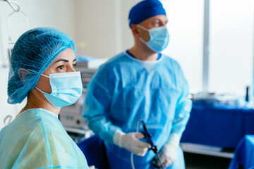 Medical staff coordinating instruments during gynecological laparoscopic operation