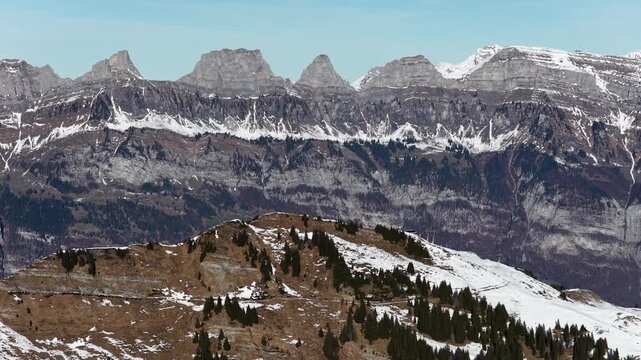 Aerial view of the Churfirsten mountain range above Walensee and Flumserberg in Switzerland, featuring dramatic alpine peaks such as Selun, Brisi, and Hinterrugg in winter scenery.