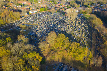 Aerial shot of Rainsough Jewish Cemetery in Prestwich, featuring dense rows of memorials surrounded by golden autumn woodland.
