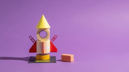 Creative colorful rocket made of blocks on purple background