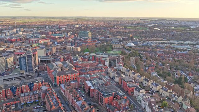 Aerial shot of the Nottingham Castle Quarter, featuring the Ducal Mansion, St Barnabas Cathedral, and the modern city centre skyline at sunrise, slow cityscape establishing shot