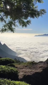 Scenic view of white clouds rolling over a mountain peak under bright sun