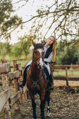 Fototapeta premium A young female jockey is sitting on her horse in show jumping training. Preparing for the competition.