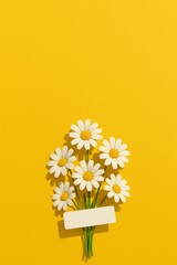 White Daisy Flowers Bouquet with Blank Label on Bright Yellow Background