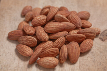 Almonds arranged on a natural wood plate, showcasing their organic texture in a warm, simple setting.
