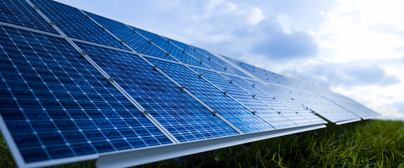 Solar panels in the sunset on a green grass.Solar panels in nature and blue sky.concept of...
