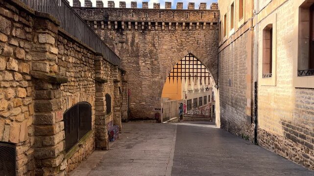 Panning video shot of the ancient city walls of Vitoria Gasteiz, showing medieval stone architecture, an old city gate and historic urban atmosphere in northern Spain. High quality 4k footage