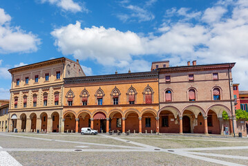 Piazza Santo Stefano showcases stunning historical buildings with arches and colorful facades. Visitors enjoy the lively space under clear blue skies, ideal for relaxation and exploration.
