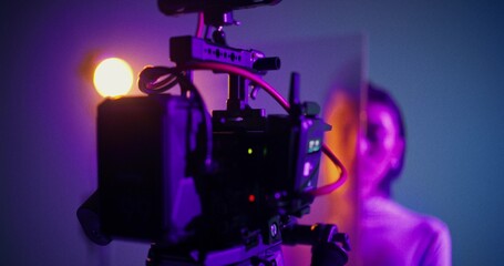 Fototapeta premium Close-up of a video camera screen during a video shoot in the studio. A model poses standing behind a corrugated glass