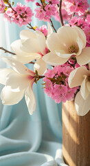 Fresh blooming magnolia and cherry blossoms in wooden vase  