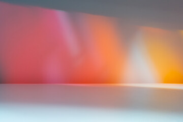 Naklejka premium Empty table on colorful orange, pink, wall background. Disco light effects. Mock up for presentation, branding products, cosmetics, food or jewelry.