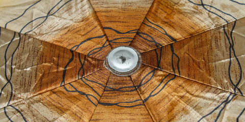 close up of abstract geometric pattern on yellow and brown umbrella surface