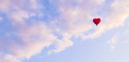 Romantic travel background with a red heart shaped balloon flying in the vast pastel sky, suitable for St Valentines day, concept of air travel and adventure, pastel tones applied
