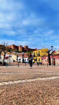 Follow me. Woman jumping over camera to famous place in Silves, travel in Algarve, Tour tourism in Portugal