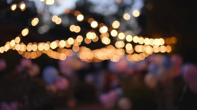 Softly glowing string lights illuminate a festive outdoor celebration filled with colorful balloons. Perfect for creating a joyful atmosphere at parties and events