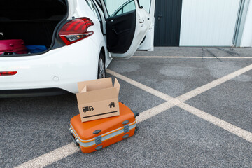 suitcases and boxes were lying on the ground next to the car.