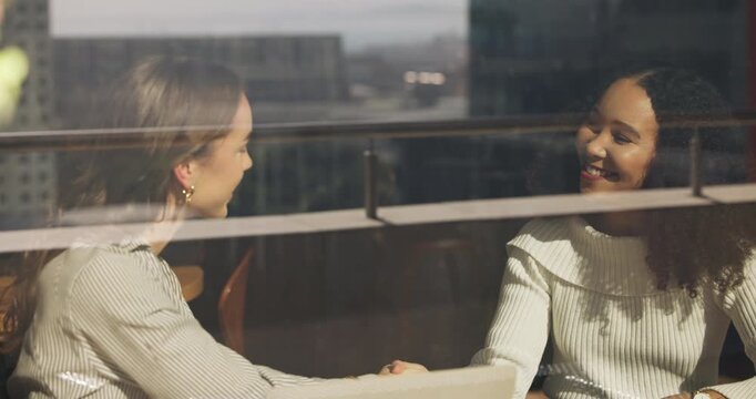 Happy, business women or meeting with handshake in cafe for agreement, deal or introduction. Female people, employees or colleagues shaking hands with smile in coffee shop for partnership or greeting