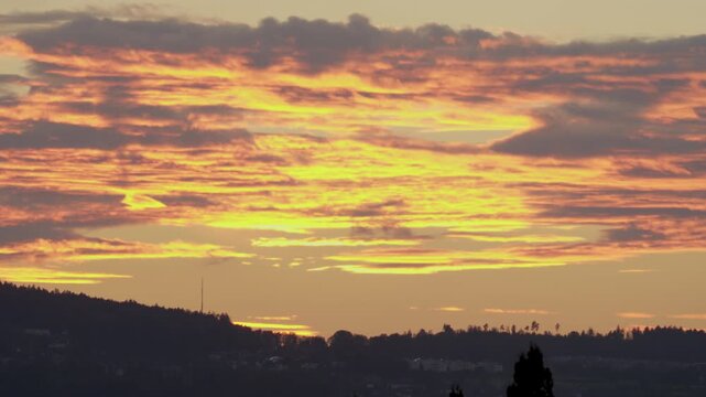 Late sunset view of the sky and a hill with a forest, Switzerland