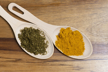 fragrant spices in wooden spoons on a cutting board top view