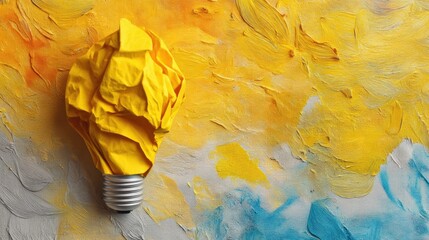 Crumbled yellow paper lightbulb on a textured paint background. Creative idea and business innovation concept for poster.