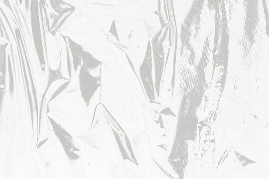 isolated image of wrinkled transparent cellophane film on a clean white background with unique creases and highlights for overlay effects